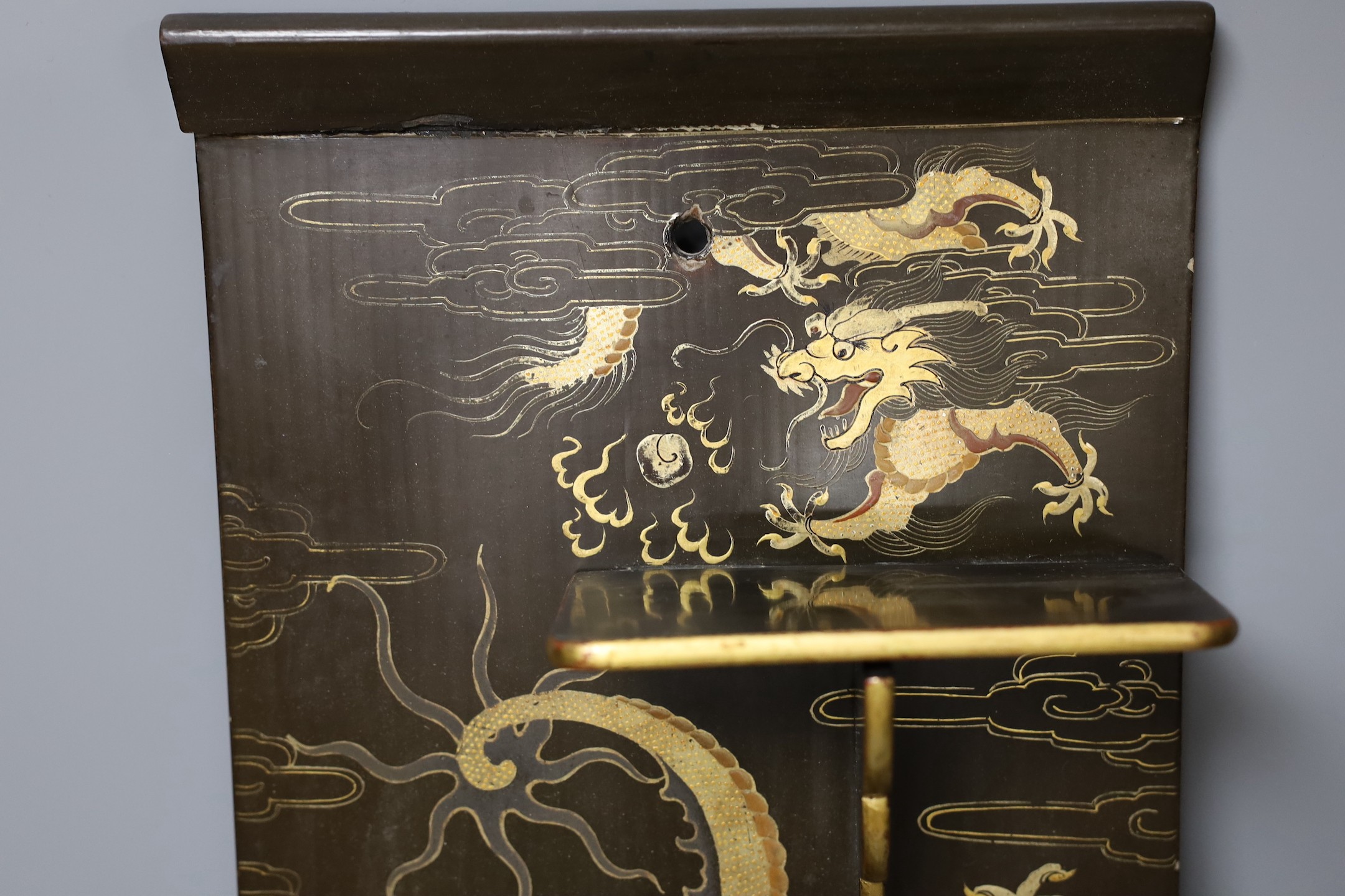 A Chinese lacquer ‘dragon’ wall shelf, 55x25cm